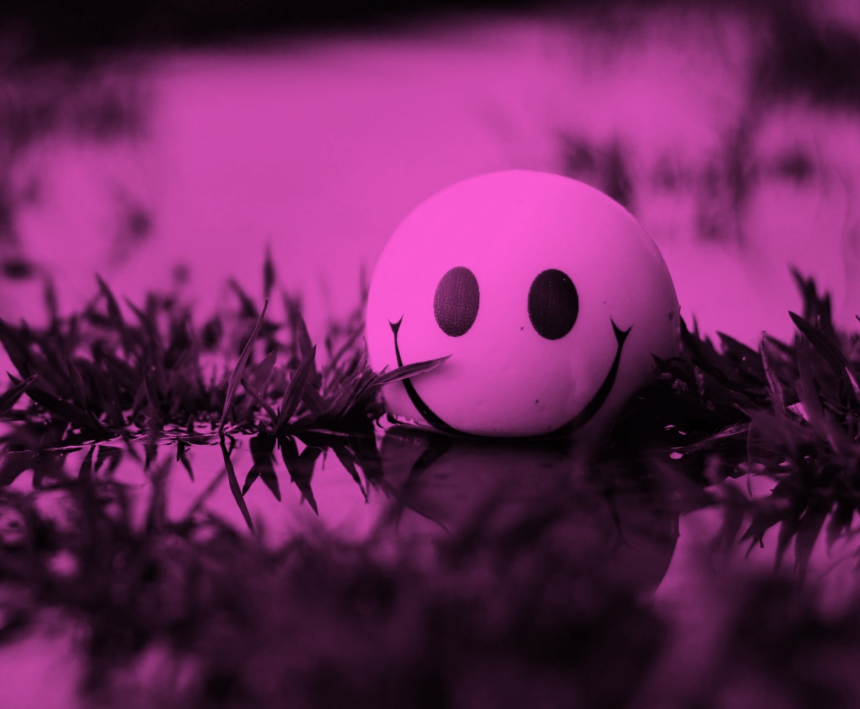 A smiley faced ball in a pink background