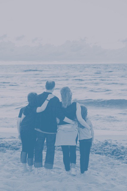  family holding eachother looking out at the vast sea.