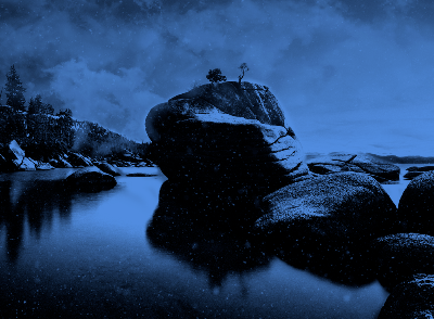  a big boulder in a body of water with smaller boulders around it